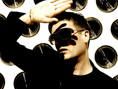 Frank Müller shielding his eyes, standing in front of a wall of records
